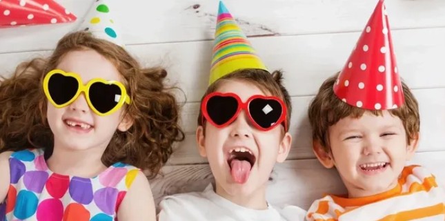 Kids in party hats and heart sunglasses